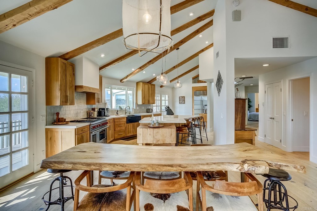 24596 Fuerte Road Temecula, CA 92590 - Photo 10 of 44 a dining hall with stainless steel appliances kitchen island granite countertop a table chairs and a refrigerator