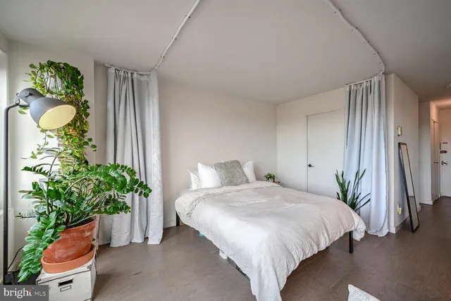 a bedroom with a bed and a potted plant