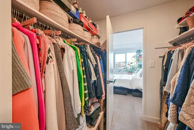 a view of walk in closet with clothes and shoes