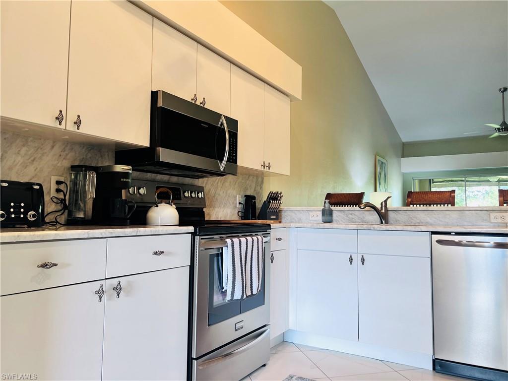 8073 Panther Trail, Unit 1404 Naples, FL 34113 - Photo 3 of 29 a kitchen with stainless steel appliances white cabinets and a sink
