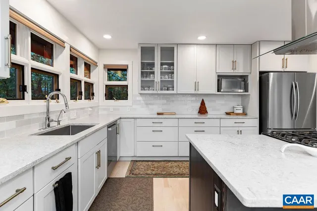 a kitchen with cabinets appliances a sink and a window