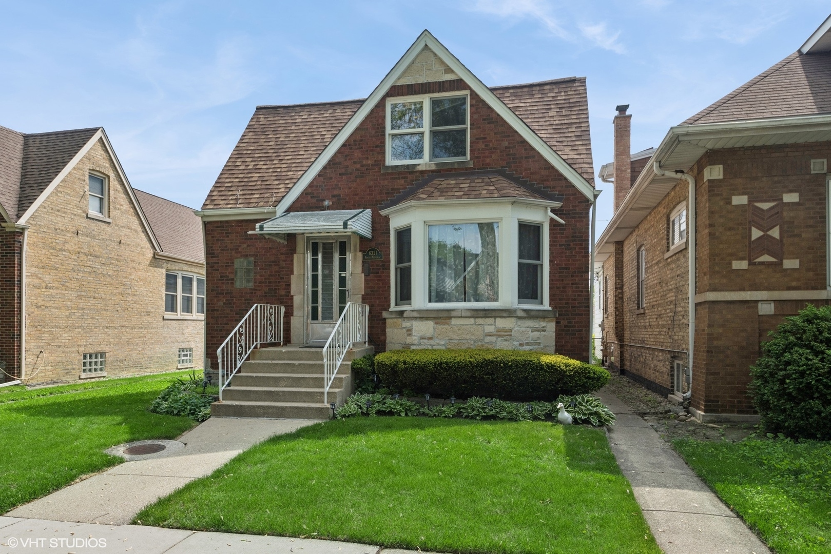6321 North Merrimac Avenue Chicago, IL 60646 - Photo 2 of 21 a view of a house with brick walls and a yard with plants