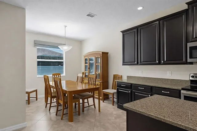 a kitchen with stainless steel appliances a dining table chairs and granite counter tops