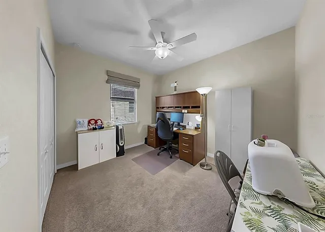 a view of a workspace with furniture and a window