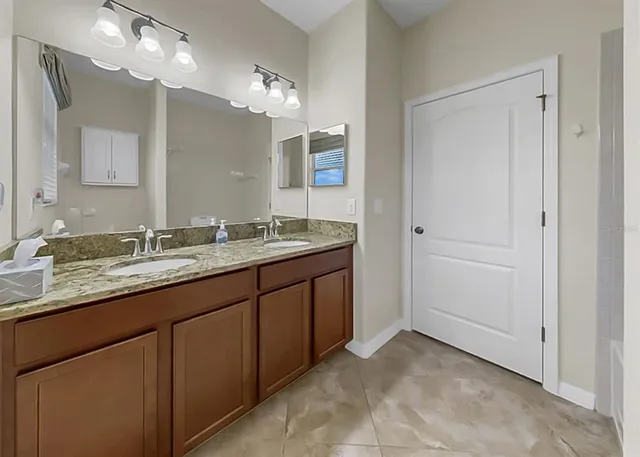 a bathroom with a granite countertop sink and a mirror