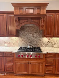a kitchen with granite countertop a stove and cabinets