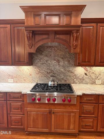 a kitchen with granite countertop a stove and cabinets