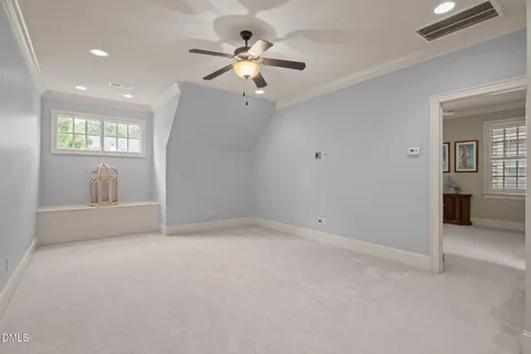 en empty room with windows and ceiling fan