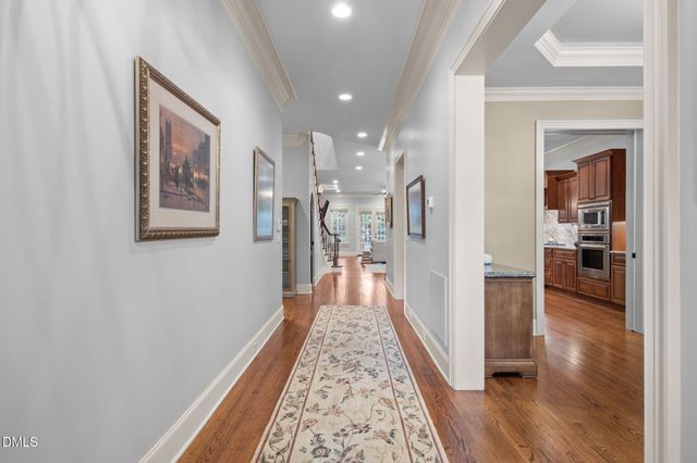 a view of a hallway with wooden floor and a living room