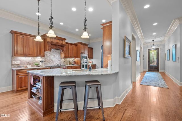 a kitchen with stainless steel appliances granite countertop wooden floors and wooden cabinets