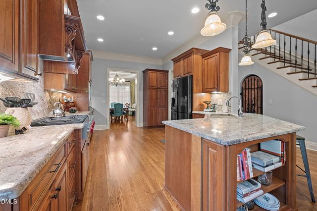 a kitchen with stainless steel appliances granite countertop a sink a stove and a wooden floors