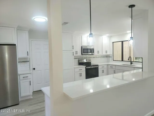 a large kitchen with cabinets and stainless steel appliances