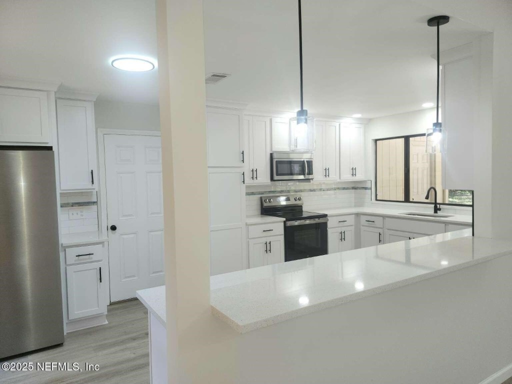 1347 Autumn Trace Fernandina Beach, FL 32034 - Photo 6 of 20 a large kitchen with cabinets and stainless steel appliances