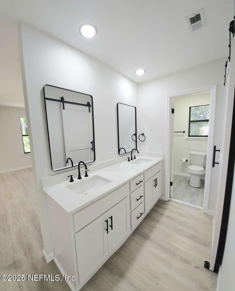 1347 Autumn Trace Fernandina Beach, FL 32034 - Photo 9 of 20 a spacious bathroom with double vanity sink a mirror and a toilet