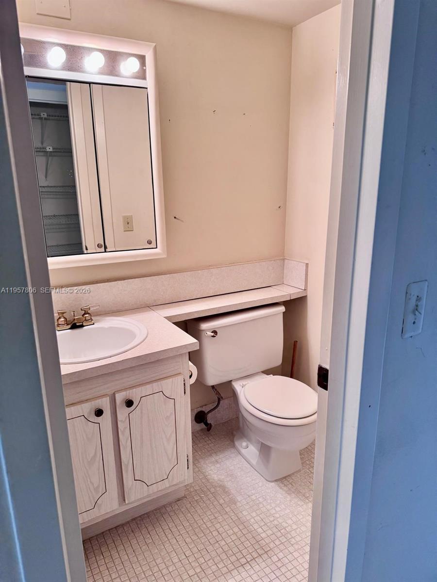 272 Dorset East, Unit G Boca Raton, FL 33434 - Photo 3 of 10 a bathroom with a toilet a sink and a vanity