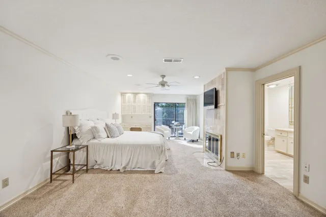 a bedroom with a bed large window and a chandelier