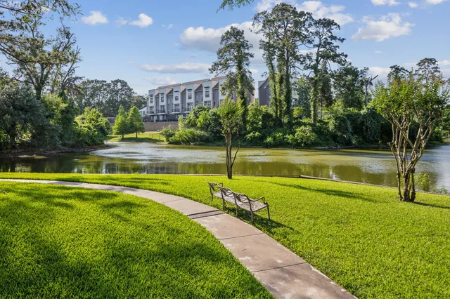 a view of a swimming pool with a yard and palm trees