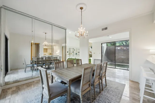 a dining room with furniture a chandelier and wooden floor