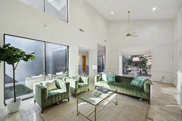 a living room with furniture potted plant and a large mirror