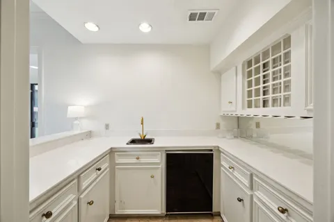 a kitchen with granite countertop white cabinets and white appliances