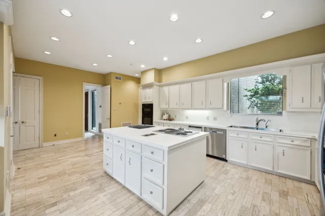 a kitchen with a stove a sink a refrigerator and a oven