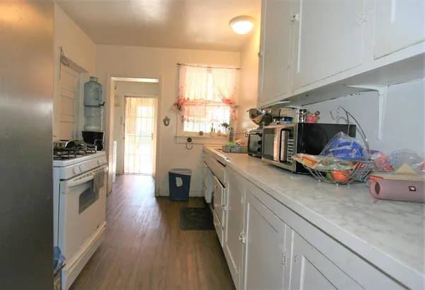 a kitchen with cabinets and wooden floor
