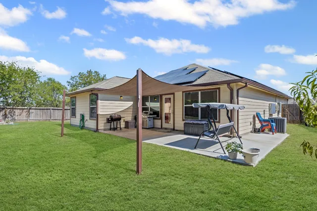 a view of a house with a backyard and a patio