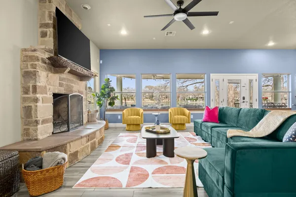 a living room with fireplace furniture and a floor to ceiling window