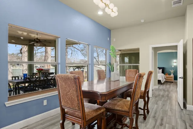 a dining room with furniture wooden floor a flat screen tv and a rug