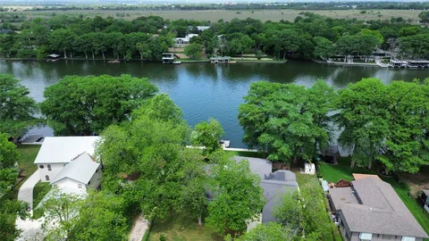 an aerial view of a house with a yard and lake view