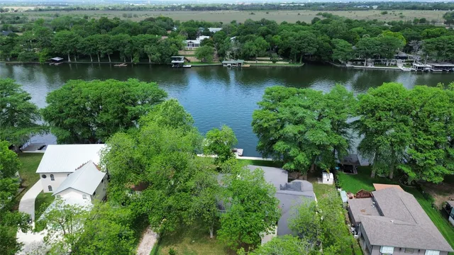 an aerial view of a house with a yard and lake view