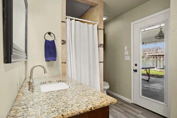 a bathroom with a granite countertop sink and a mirror