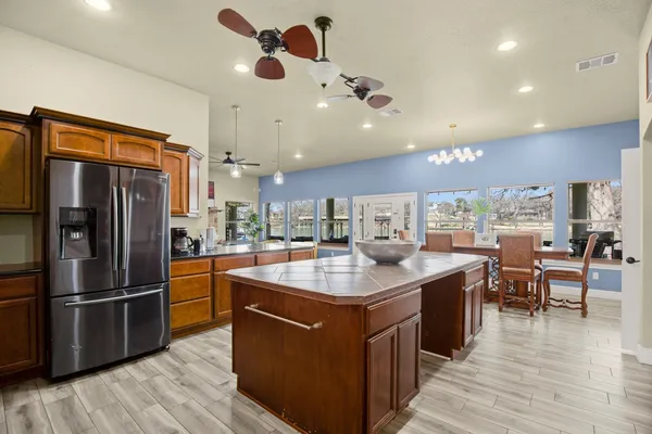 a kitchen with stainless steel appliances granite countertop a sink a stove and a refrigerator