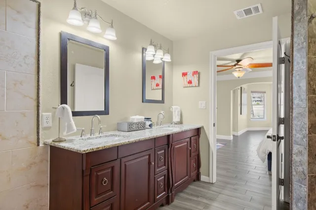 a bathroom with a granite countertop shower and a sink
