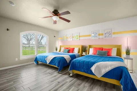 a bedroom with two beds and a large window