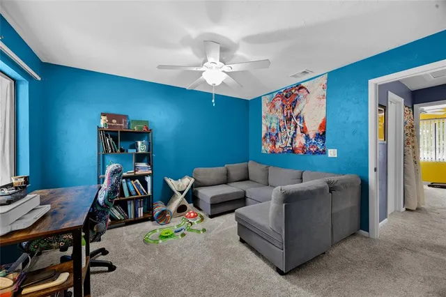 a living room with furniture and a work place with a bookshelf