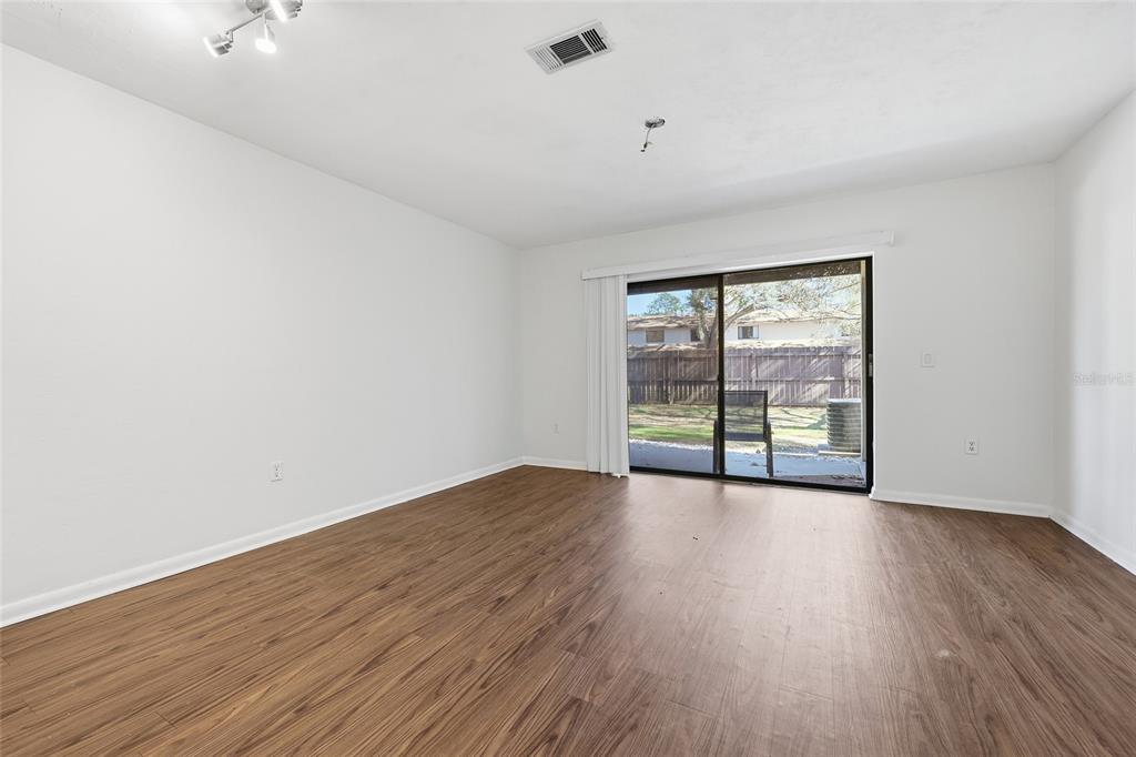 2735 Southwest 35th Place, Unit 306 Gainesville, FL 32608 - Photo 4 of 17 a view of an empty room with wooden floor and a window