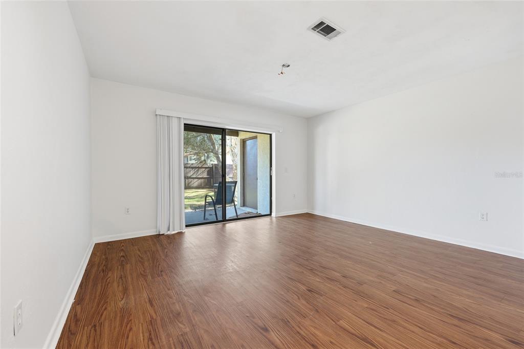 2735 Southwest 35th Place, Unit 306 Gainesville, FL 32608 - Photo 8 of 17 a view of an empty room with wooden floor and a window