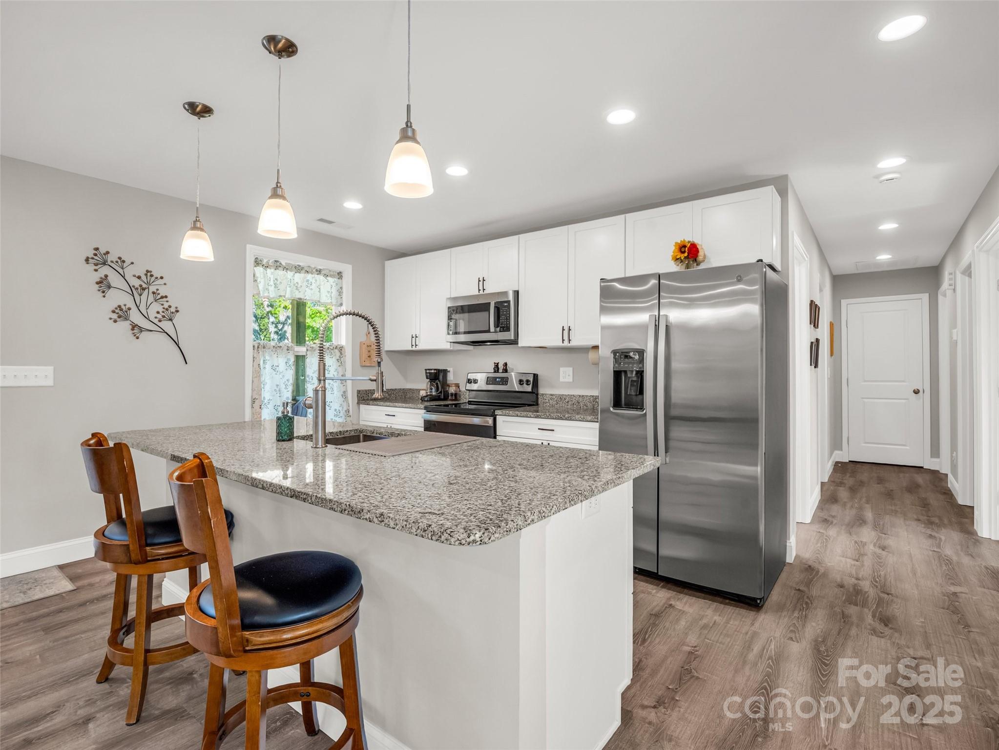 566 Blue Ridge Road Black Mountain, NC 28711 - Photo 24 of 41 a kitchen with granite countertop a center island a sink stainless steel appliances and cabinets