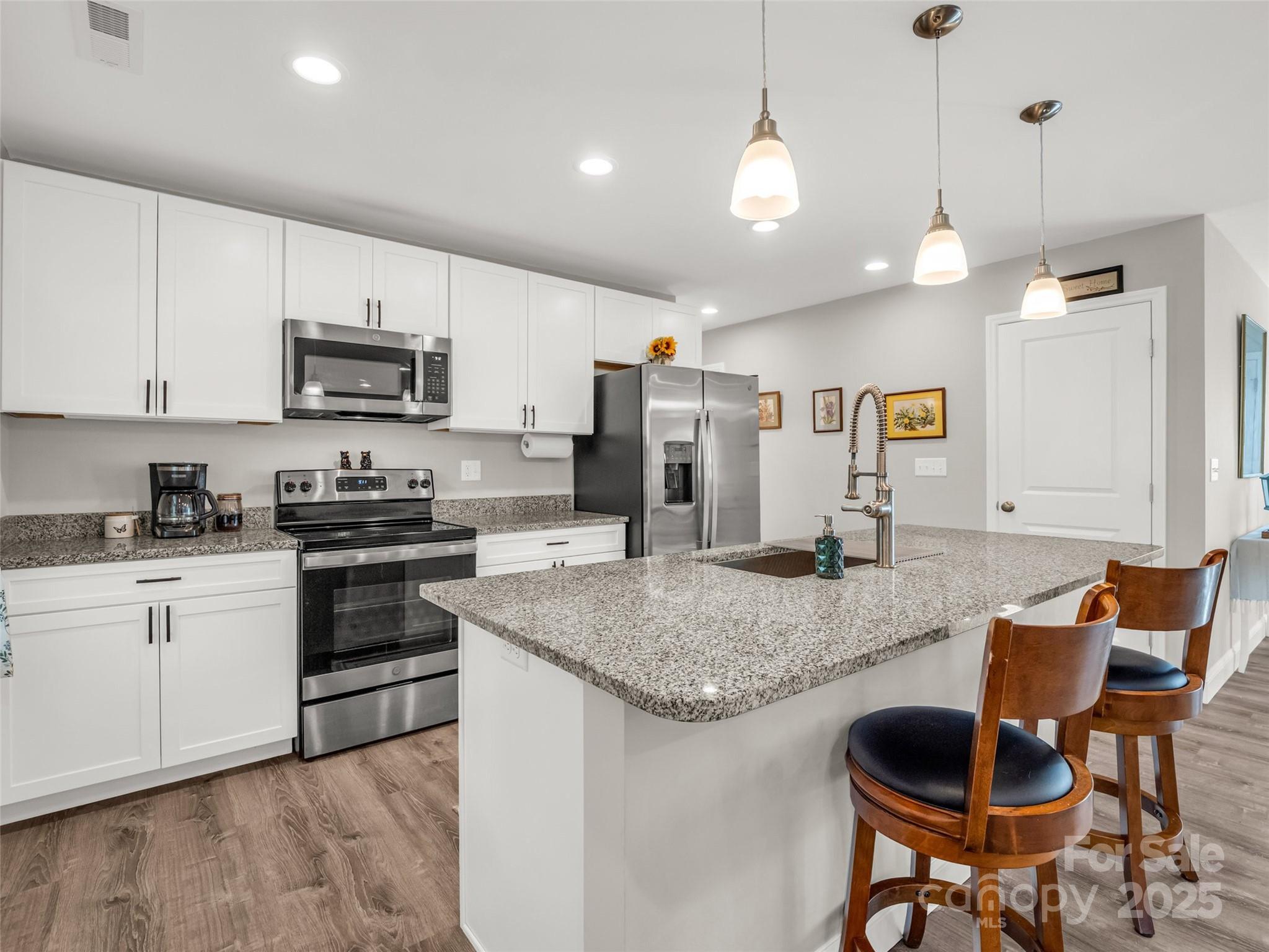 566 Blue Ridge Road Black Mountain, NC 28711 - Photo 25 of 41 a kitchen with stainless steel appliances granite countertop a stove a sink a microwave a refrigerator and cabinets
