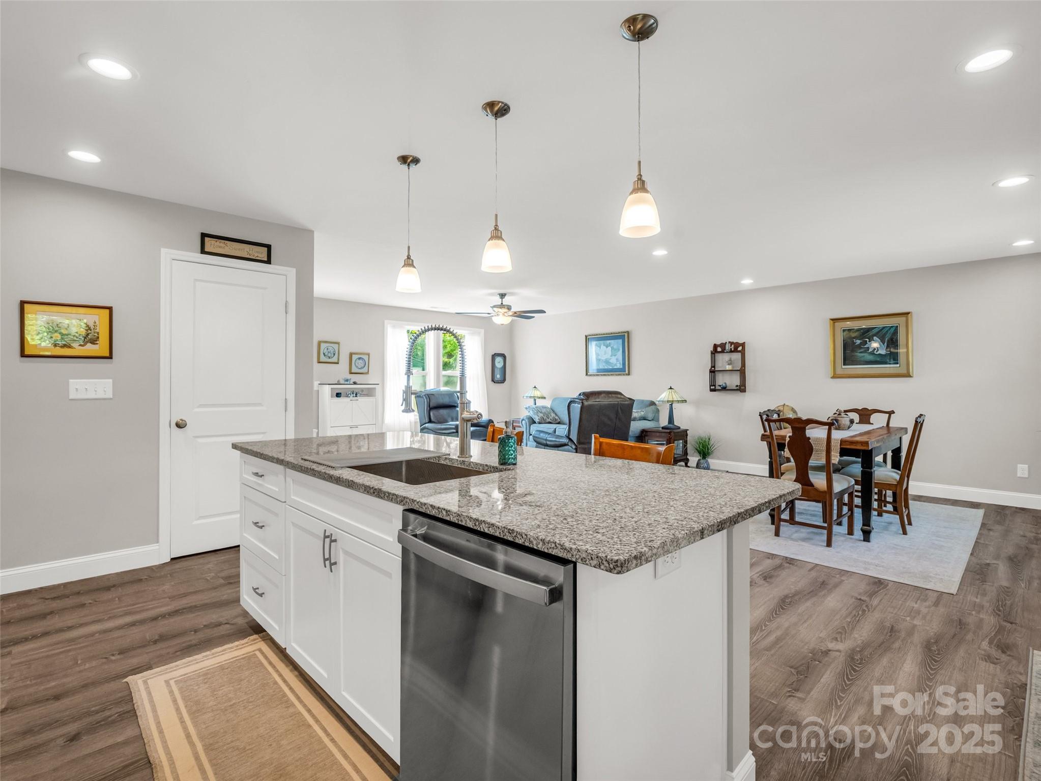 566 Blue Ridge Road Black Mountain, NC 28711 - Photo 26 of 41 a kitchen with stainless steel appliances granite countertop a stove top oven a dining table and chairs with wooden floor