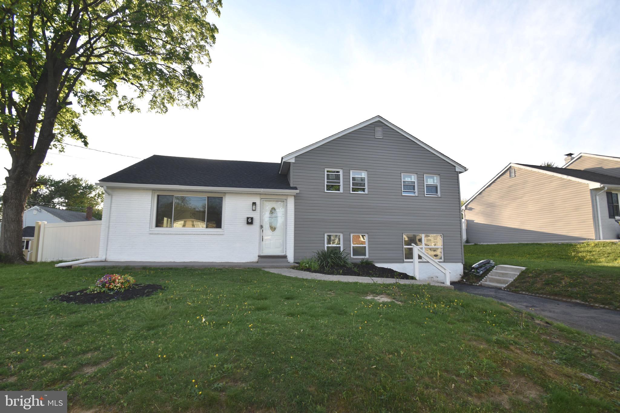 a front view of a house with a garden and yard