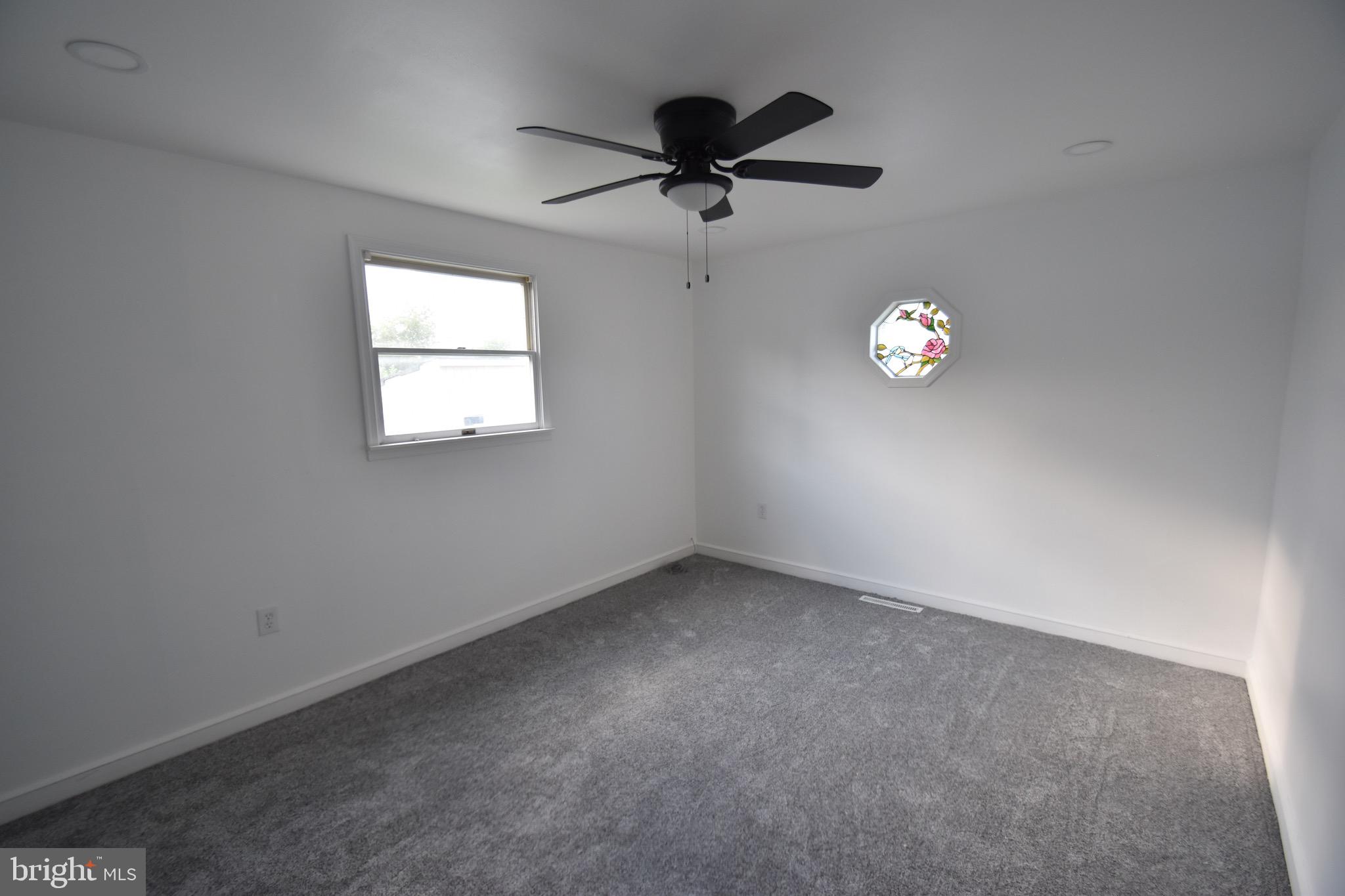 6 Russell Road New Castle, DE 19720 - Photo 12 of 16 an empty room with a window and a fan