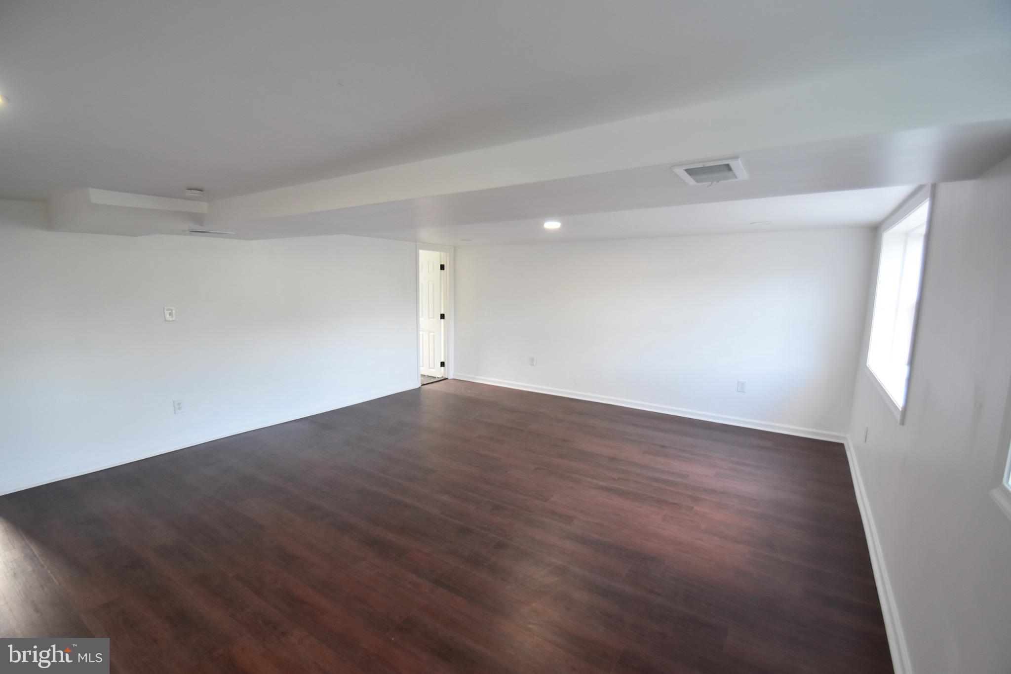 6 Russell Road New Castle, DE 19720 - Photo 9 of 16 a view of an empty room with wooden floor and a window