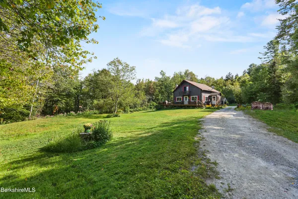 a view of a house with a big yard and large trees