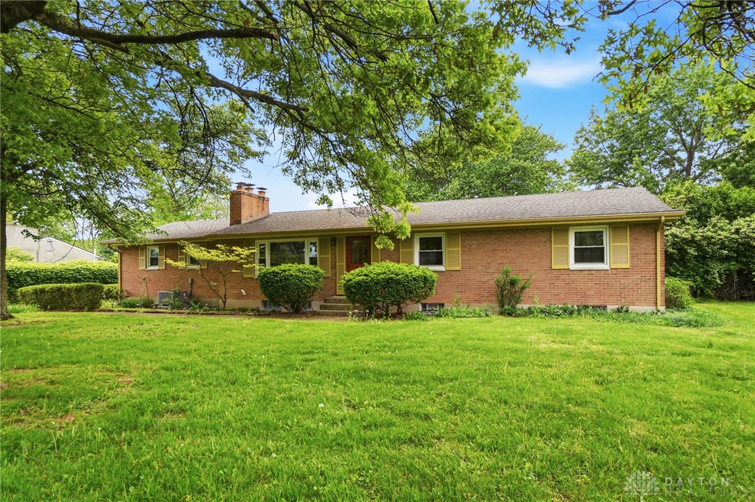 6119 Flemington Road Dayton, OH 45459 - Photo 74 of 76 This classic brick residence features a lush lawn and mature trees, offering a serene outdoor setting.