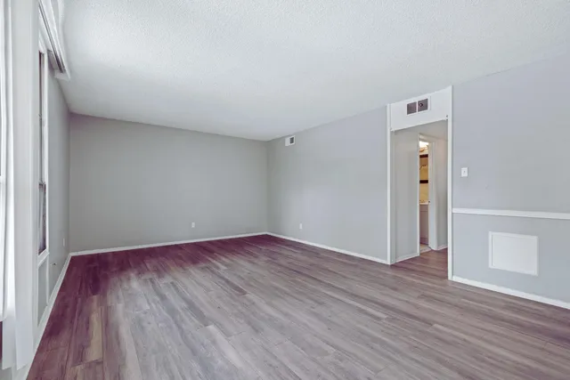 an empty room with wooden floor and closet