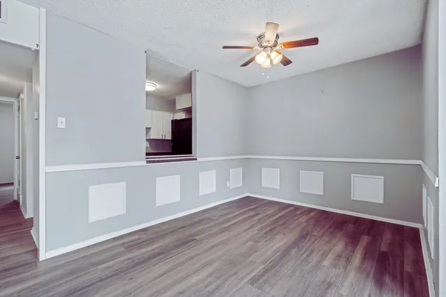 a view of an empty room with wooden floor