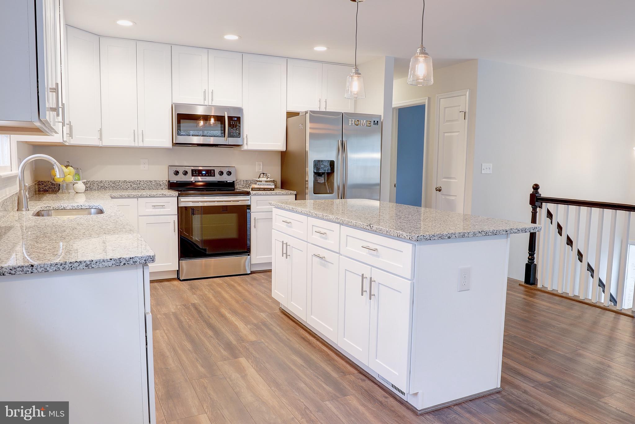 695 Hillmeade Road Edgewater, MD 21037 - Photo 11 of 28 a kitchen with stainless steel appliances granite countertop a refrigerator a stove top oven a sink and dishwasher with wooden floor