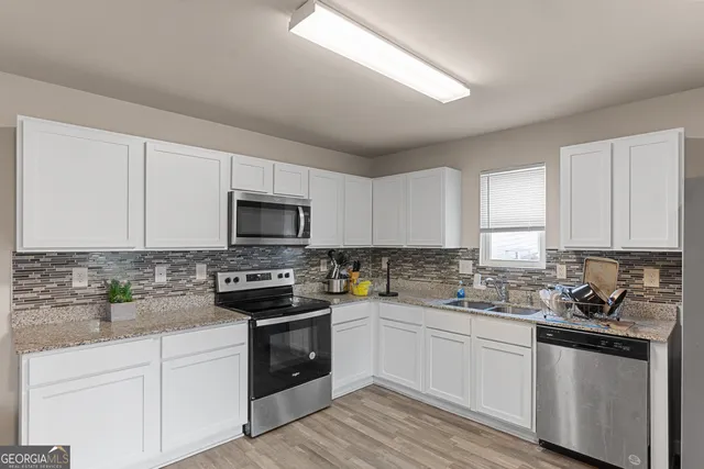 a kitchen with sink a microwave and cabinets